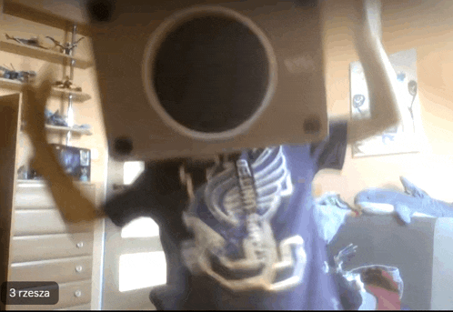 a person wearing a blue shirt with a skeleton on it and the number 3 on the bottom right