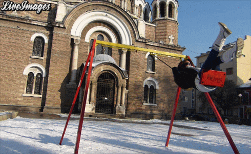 a person on a swing in front of a building with the words live images on the bottom