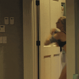 a woman in lingerie is standing in a doorway