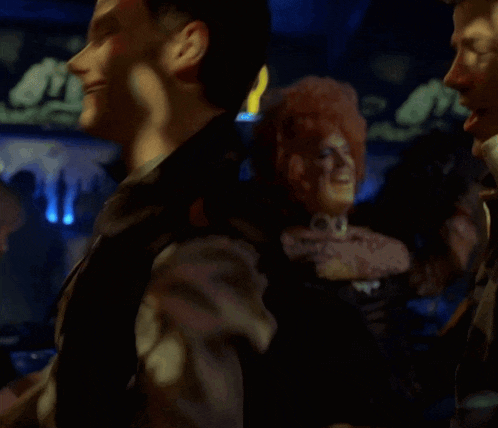 a group of people are dancing in front of a sign that says r on it