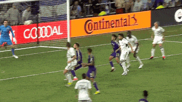 a group of soccer players on a field with an ad for continental behind them