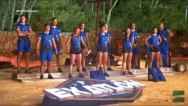 a group of athletes standing in front of a sign that says exatlon