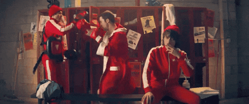 a group of people standing in front of lockers with one of them wearing a jacket that says ' no tickets ' on it