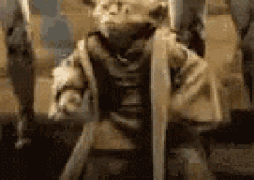 a close up of a statue of yoda holding a stick .