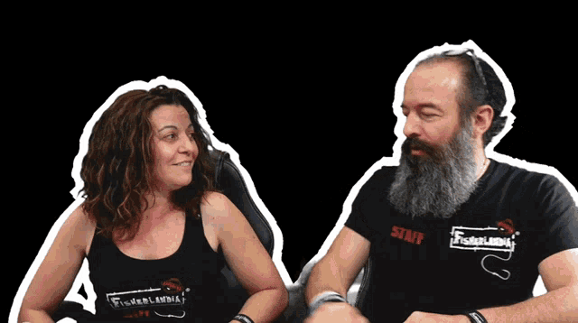 a man and a woman are sitting next to each other and the woman is wearing a shirt that says staff