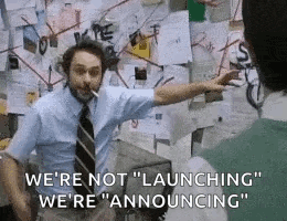 a man in a suit and tie is smoking a cigarette and pointing at a bulletin board .