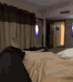 a blurred image of a bedroom with a bed and a television