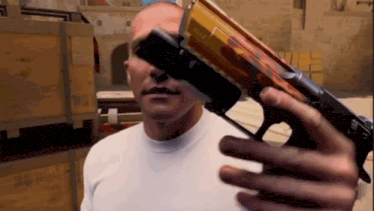 a man is holding a gun in his hand .