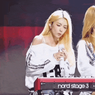 a girl singing into a nord stage 3 keyboard