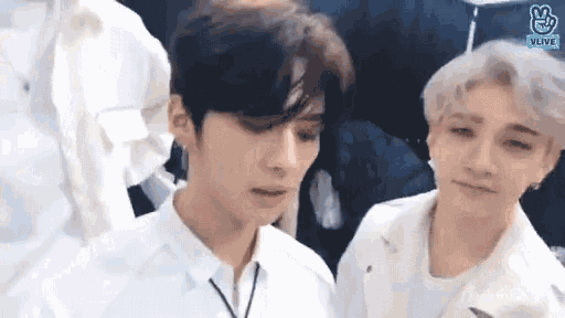 a couple of young men are standing next to each other and looking at each other .