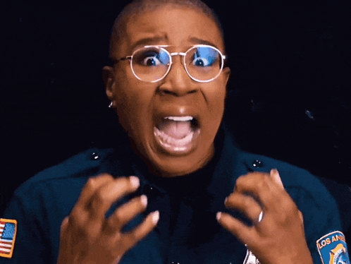 a woman wearing glasses and a los angeles patch on her uniform is making a funny face