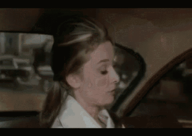 a man in a suit and tie is yawning while sitting in a car .