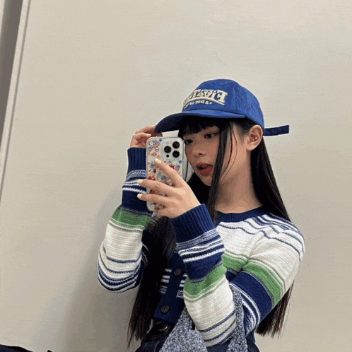 a girl is taking a picture of herself in a mirror wearing a hat that says ' i love you '