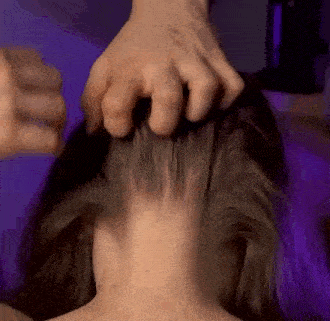 a close up of a person 's hand on a woman 's hair .