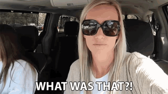 a woman wearing sunglasses says what was that in a car