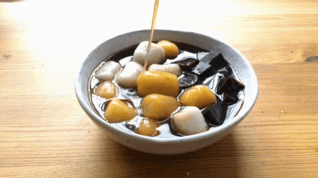 a bowl of food is being poured into a bowl on a table .