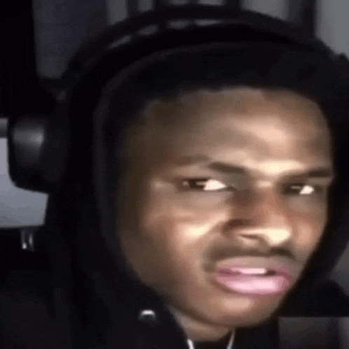 a young man wearing headphones is making a funny face .