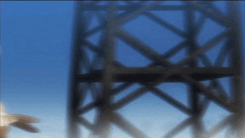 a blurred image of a building with a blue sky in the background