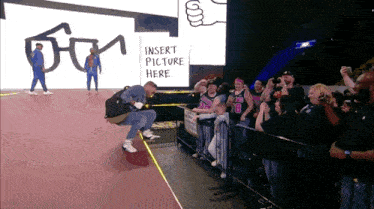 a man is squatting down in front of a crowd with a sign that says insert picture here