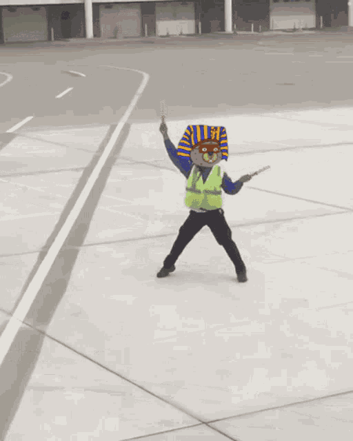 a man with a pharaoh mask on his head is holding a red baton