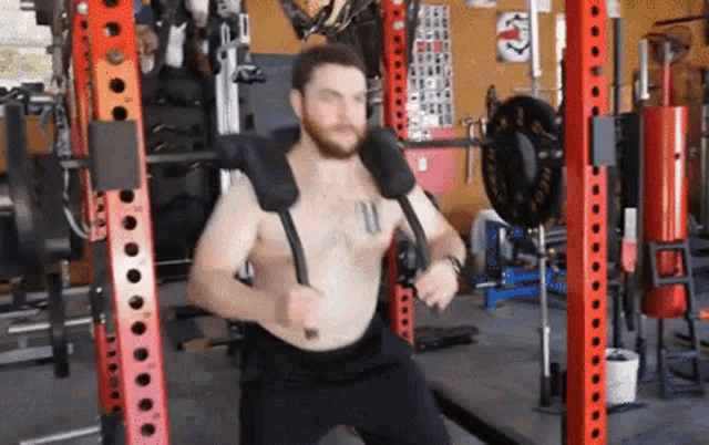 a shirtless man is doing exercises in a gym .