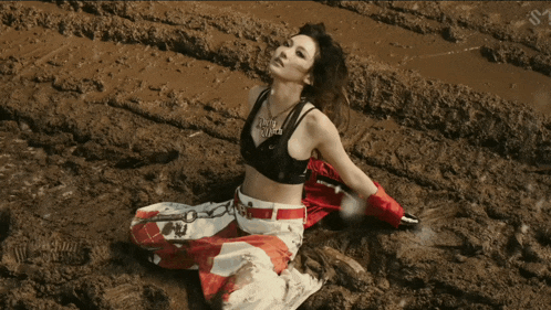 a woman is kneeling in the mud with a necklace that says ' i love you ' on it