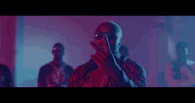 a group of men are standing next to each other in a dark room .