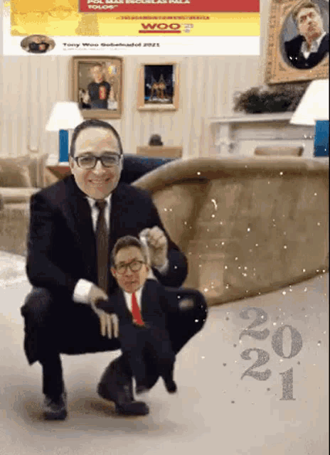 a man in a suit and tie is squatting down next to a smaller man .