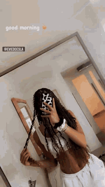 a woman taking a selfie in front of a mirror with the words good morning written on the bottom