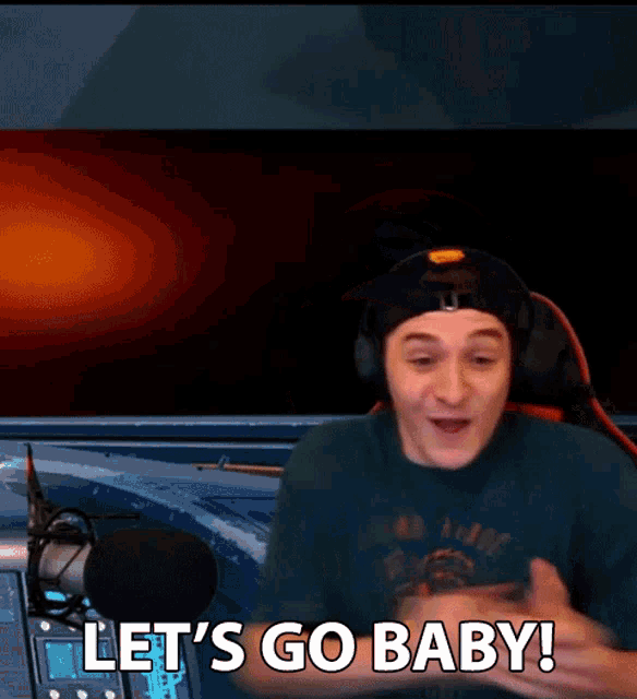 a man sitting in front of a microphone with the words let 's go baby