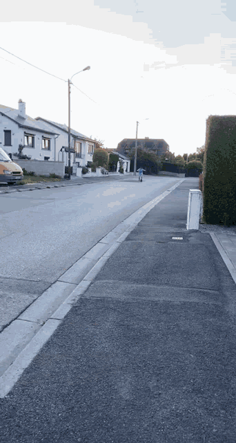a person walking down a street with a yellow van parked on the side