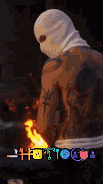 a man wearing a ski mask is holding a fire in front of him
