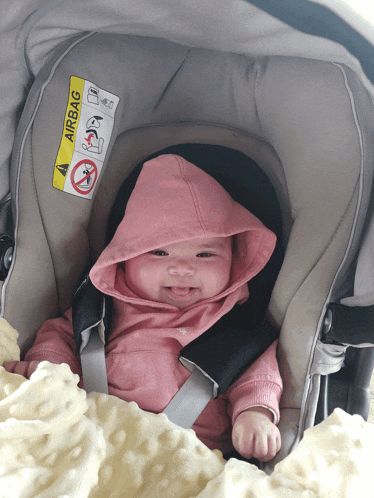 a baby is sitting in a car seat with an airbag warning on the side