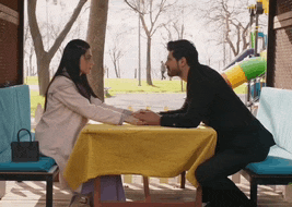 a man and woman are holding hands at a table