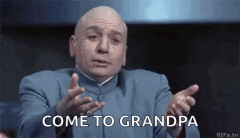 a bald man in a blue suit is making a funny face and saying come to grandpa .