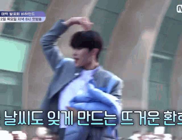 a blurry picture of a man with korean writing on the bottom right
