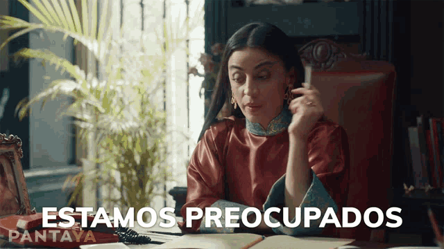 a woman sits at a desk with the words " estamos preocupados " written on the bottom