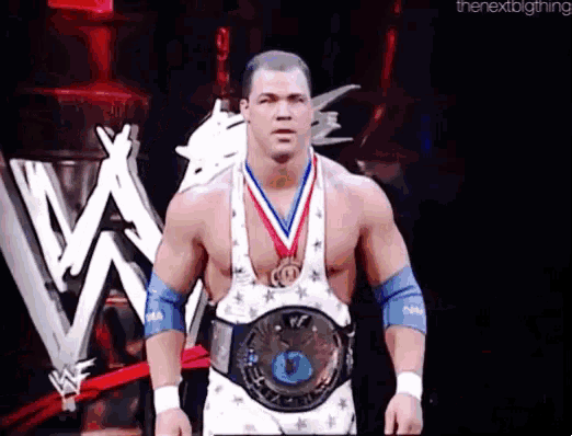 a wrestler is wearing a medal around his neck and a belt with the number 3 on it