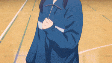 a girl in a blue jacket is standing on a court
