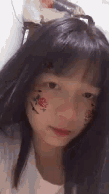 a girl with a tattoo on her face is crying .