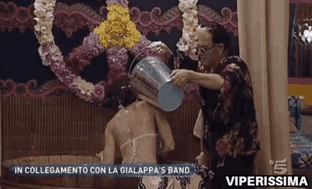 a man is pouring water on a woman in a bathtub with the words viperissima on the bottom
