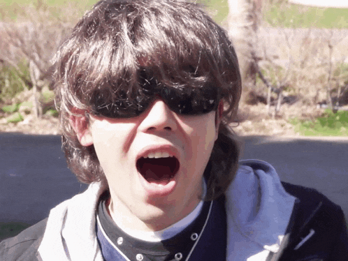 a young man wearing sunglasses and a nike hoodie