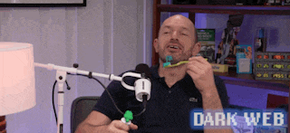 a man is brushing his teeth in front of a microphone with the words dark web on the bottom right