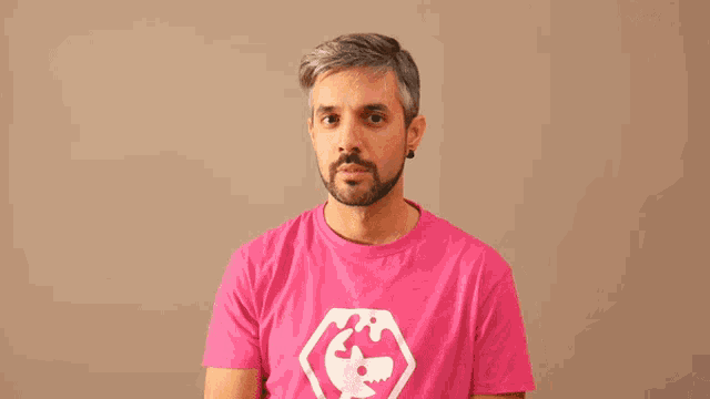 a man wearing a pink t-shirt with a skull on it