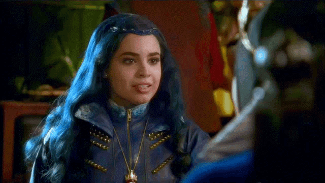 a girl with blue hair is smiling and wearing a jacket .