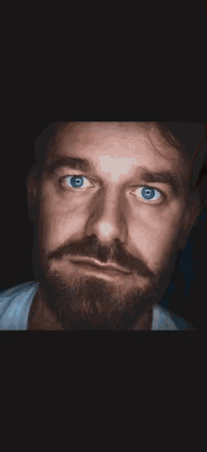 a closeup of a man 's blue eye with a beard