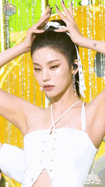 a woman is wearing a white top with a white scarf in her hair