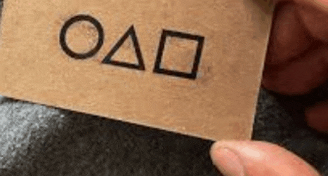 a person is holding a piece of paper with the letters o and a drawn on it .