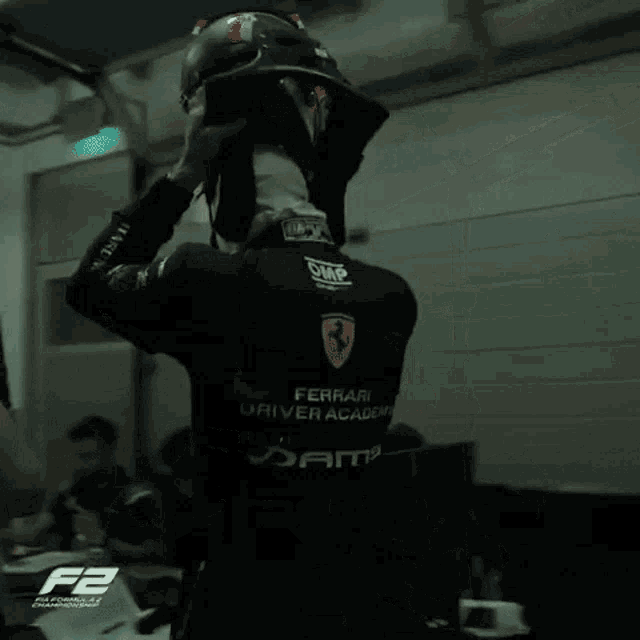 a man wearing a black shirt that says ferrari driver academy on it