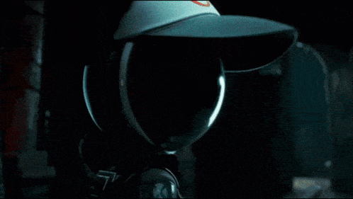 a person is standing in a dark room with a sword in their hand